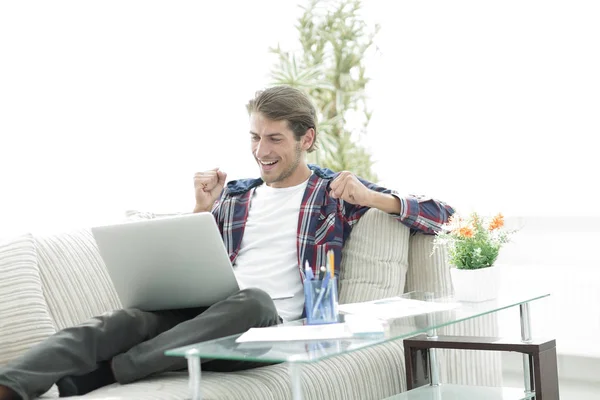 Mutlu genç adam evden dizüstü bilgisayar ile çalışma. — Stok fotoğraf