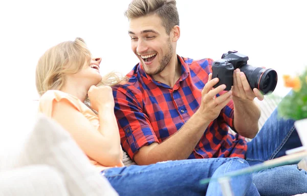 Moderna pareja joven riendo y discutiendo las fotos en la cámara — Foto de Stock