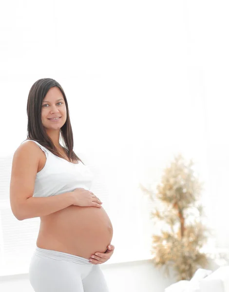 Retrato de una joven embarazada sobre un fondo claro . — Foto de Stock
