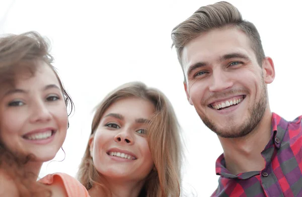 Zbliżenie trójki młodych ludzi uśmiechniętych na białym tle — Zdjęcie stockowe