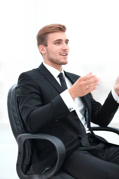 Primer plano. hombre de negocios hablando mientras está sentado en una silla . — Foto de Stock