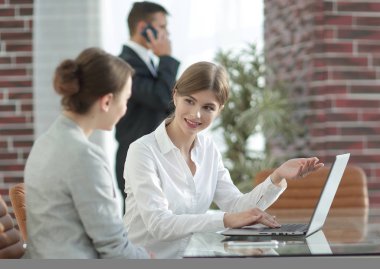 Yöneticisi ve istemci laptop ile alınan bilgi tartışıyorlar