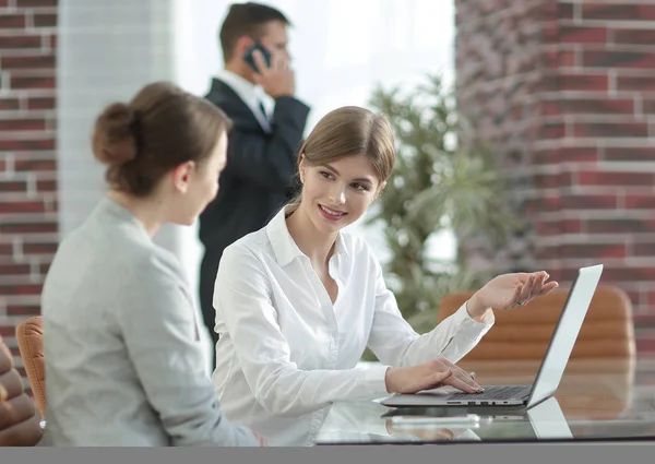 Yöneticisi ve istemci laptop ile alınan bilgi tartışıyorlar