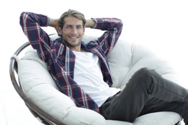 yakın çekim. başarılı bir adam büyük bir yuvarlak rahat sandalyede oturuyor