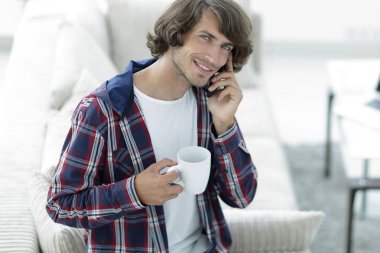 güzel bir fincan adamla bir dizüstü bilgisayar önünde oturur.