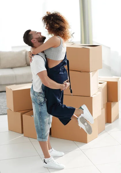 Jovem casal abraçando uns aos outros no novo apartamento . — Fotografia de Stock