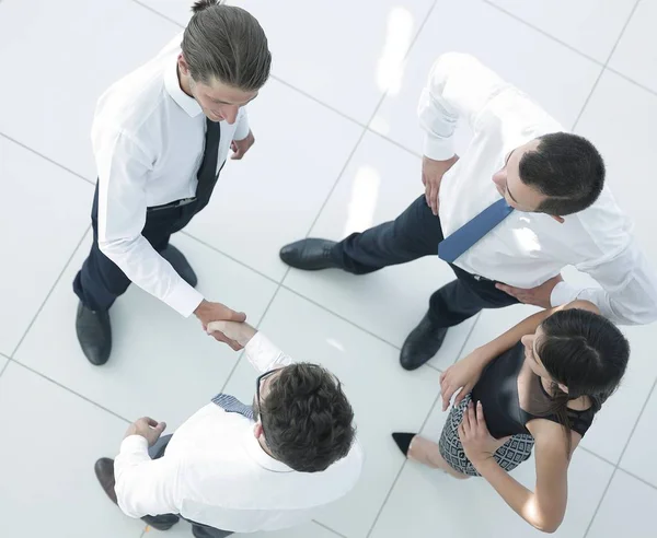 View from the top. colleagues shaking hands in office lobby. — Stock Photo, Image