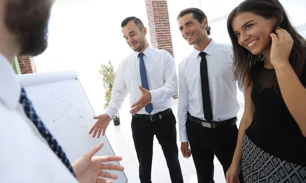 iş takım üzerinde boş bir flipchart işaret eden işadamı.