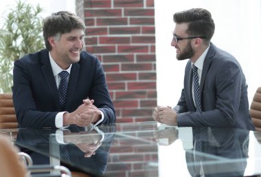 iki işadamı görevleri Office masada oturan tartışıyor.