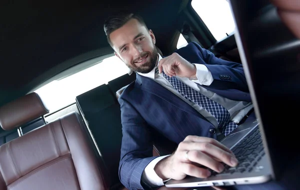 Jistý podnikatel sedí v autě — Stock fotografie