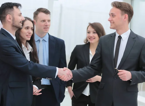 Business team looks at the hand shake business partners — стоковое фото