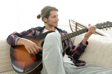 oturma odasında kanepede oturup gitar ile Modern adam.