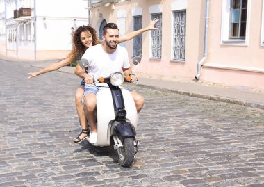 mutlu genç bir çift bir scooter üzerinde eğleniyor