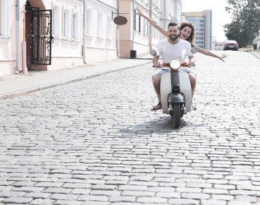 mutlu genç bir çift bir scooter üzerinde eğleniyor
