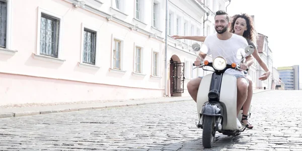 Glückliches junges Paar, das Spaß auf einem Roller hat — Stockfoto