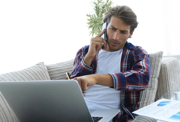 Uomo moderno che lavora con documenti finanziari in soggiorno — Foto Stock