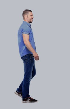 yan görünüm, beyaz arka plan üzerinde yürüyen bir gülümseyen casual adam