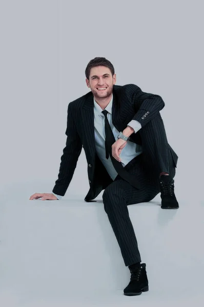 Handsome young business man sitting on a white modern chair — Stock Photo, Image