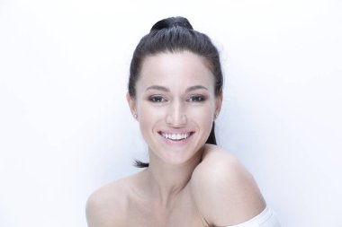 günlük makyaj ile gülümseyen bir kadının yakın çekim yüz.