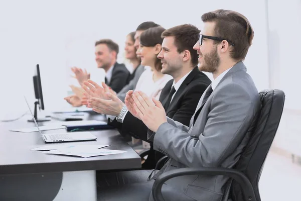 Torcendo equipe de negócios sentado na mesa — Fotografia de Stock