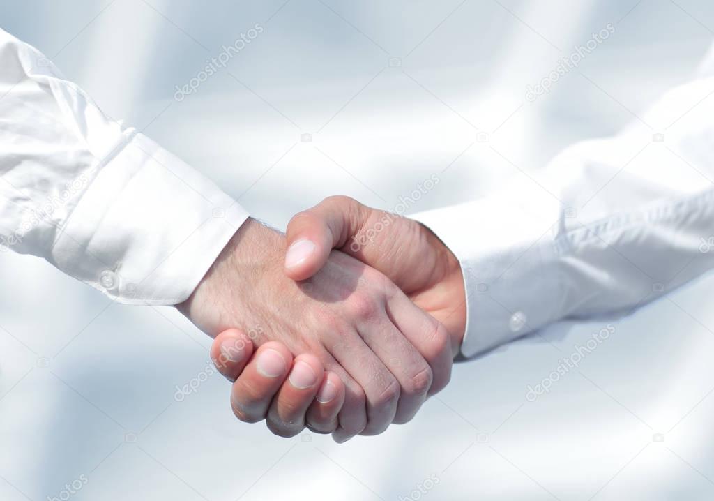 Close-up photo of handshake of two successful businessmen