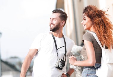 Genç çift mutlu görünürken bir rehbere bakıyor.