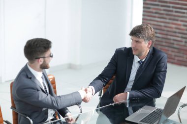 İş adamları el sıkışır, masada otururlar. .