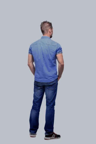 Young man from the back - looking at something over a white back — Stock Photo, Image