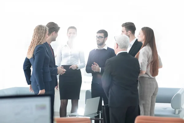 Успешная бизнес-команда обсуждает документы и идеи, стоящие возле рабочего стола — стоковое фото
