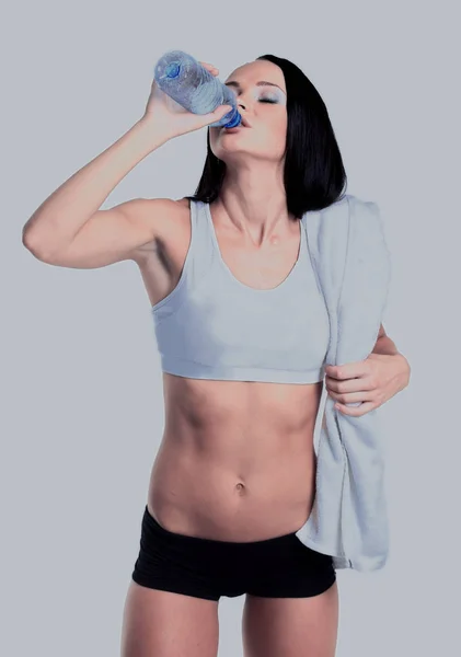 Glücklich lächelnde Frau in Sportkleidung, die Wasser trinkt, isoliert vor weißem Hintergrund — Stockfoto