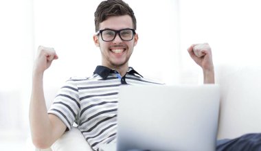 mutlu adam kanepede oturan dizüstü bilgisayar ile