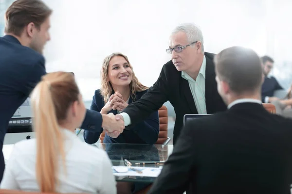 Partner commerciali stringono la mano nella sala conferenze — Foto Stock