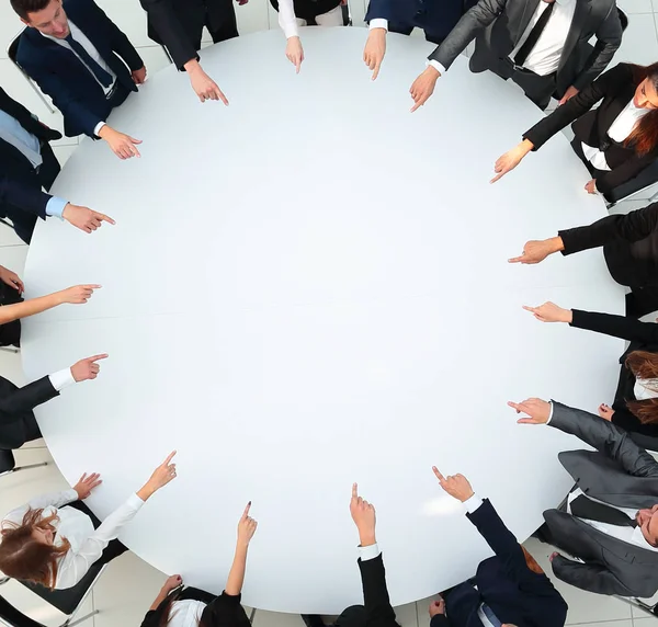 Closeup .business team pointing in the center of the table. — Stock Photo, Image