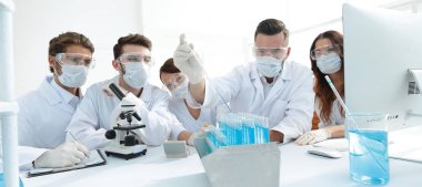 tıp doktorları laboratuarda test tüpleri ve mikroskop ile çalışıyoruz