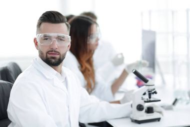 mikrobiyolog ve meslektaşları modern bir laboratuarda oturuyor