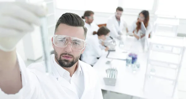 Image is blurred. young scientist holding tube with the reagents — Stock Photo, Image