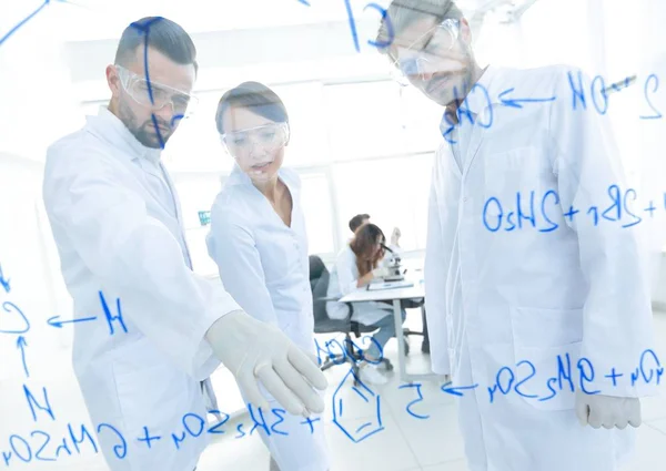 Group of young scientists talking in a lab — Stock Photo, Image