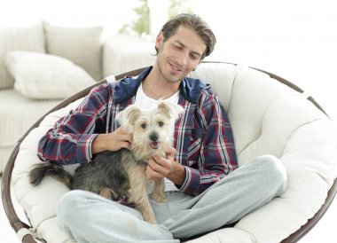 yakışıklı olan büyük bir koltukta oturan bir köpekle.