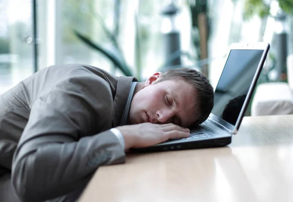 Un uomo d'affari stanco che dorme sul suo portatile in ufficio — Foto Stock