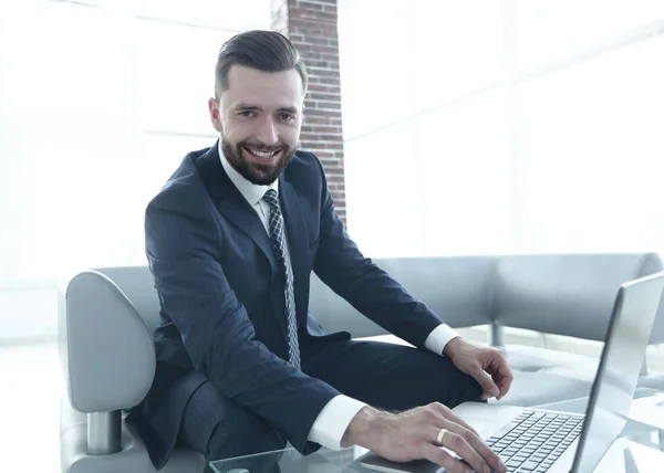 Modern man working on laptop in office lobby. — Stock Photo, Image