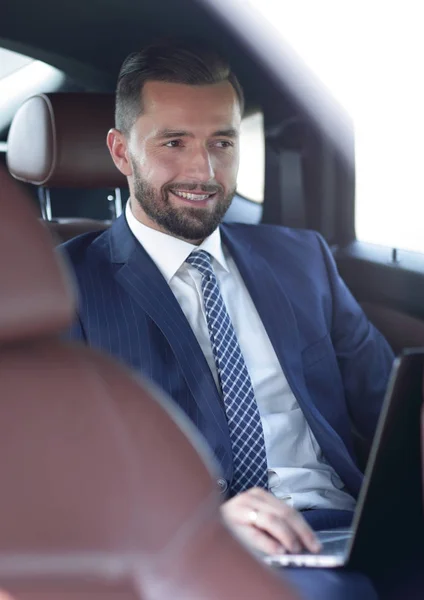 Retrato de un hombre de negocios en el asiento trasero de un coche — Foto de Stock