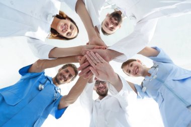 En alttaki görüntüde. Tıp merkezindeki bir grup doktor ellerini birbirine yapıştırdı.
