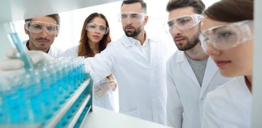 arka plan görüntüsü sıvı cam tüp içinde eğitim microbiologists oluşan bir gruptur.