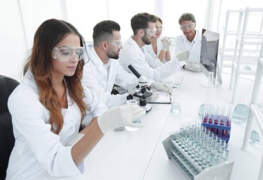 Grup genç bilim adamı laboratuvarda çalışan.