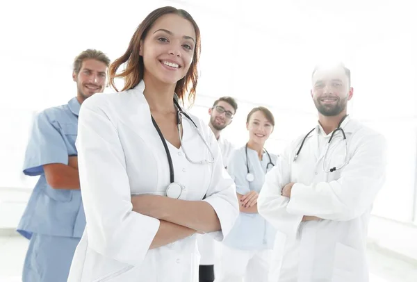 Attraktiva kvinnliga läkare med medicinska stetoskop framför medicinsk grupp — Stockfoto