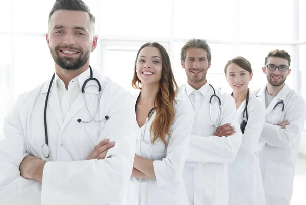 Ομάδα ευτυχισμένος επιτυχημένη γιατρών που στέκεται σε μια γραμμή με το νοσοκομείο — Φωτογραφία Αρχείου