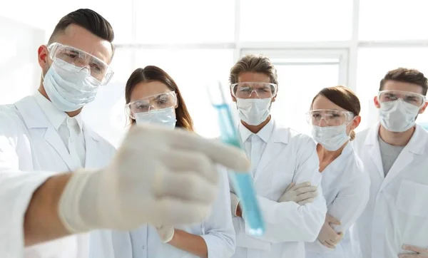 A imagem de fundo é um grupo de profissionais médicos que trabalham com líquidos em laboratório — Fotografia de Stock