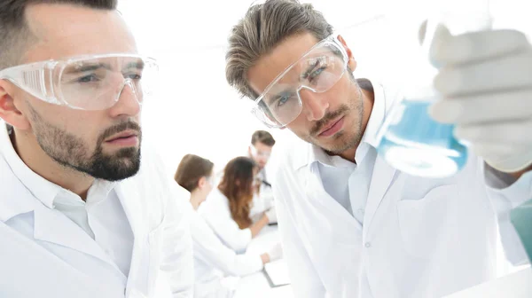 Closeup. scientist and assistant studying the solution in the glass tube — Stock Photo, Image