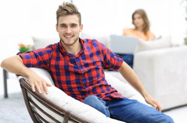 büyük sandalyede oturan genç adam