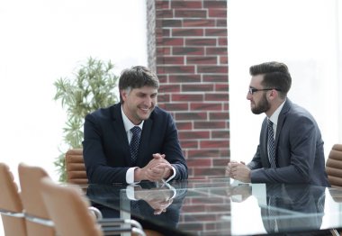 iki işadamı görevleri Office masada oturan tartışıyor.